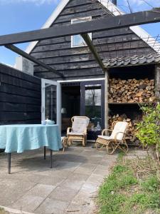 a patio with two chairs and a table at TIJ Tiny house aan het getijdewater in Zierikzee in Zierikzee