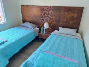 two beds sitting next to each other in a room at Condo Playa Hermosa, Puntarenas in Muñeco