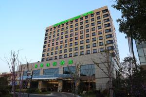 a building with a green sign on top of it at Evergreen Laurel Hotel, Shanghai in Shanghai