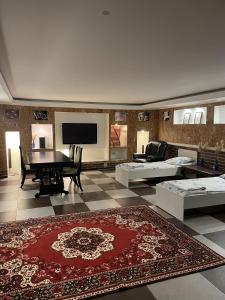 ein Wohnzimmer mit einem Tisch und einem Teppich in der Unterkunft Mang’o Hostel in Aqtau