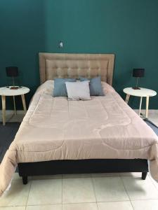 uma cama grande num quarto com duas mesas em Sayani Posada em Chilecito