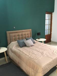duże łóżko w sypialni z dwoma stołami w obiekcie Sayani Posada w mieście Chilecito