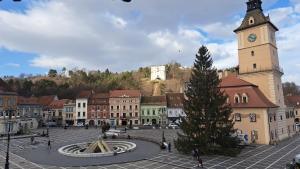 a town with a clock tower and a christmas tree at 4 Rooms Piata Sfatului in Braşov +68 photos