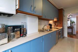 een keuken met blauwe kasten en een wastafel bij Anduriña16 by VigoVacaciones in Vigo