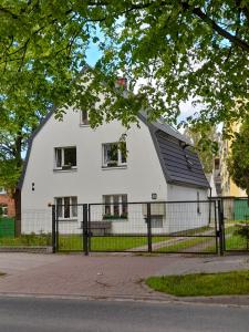 a white house with a fence in front of it at Apartament LUA in Ustka