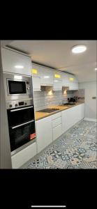 La cuisine est équipée de placards blancs et d'un four. dans l'établissement The Captains Wheel, à Skerries