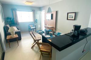 uma cozinha e sala de estar com um balcão e cadeiras em Vila das Dunas - aluguel de temporada em Cabo Frio