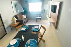 un soggiorno con tavolo, sedie e divano di Vila das Dunas - aluguel de temporada a Cabo Frio