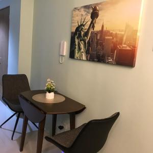 una mesa y sillas en una habitación con una foto en la pared en MOA Pasay, Shore 3 Residences - Modern Luxury Condo en Manila