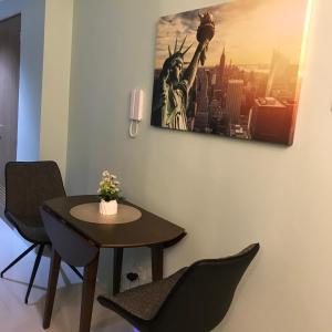 a table and chairs in a room with a picture on the wall at MOA Pasay, Shore 3 Residences - Modern Luxury Condo in Manila