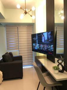 a living room with a large flat screen tv on a table at MOA Pasay, Shore 3 Residences - Modern Luxury Condo in Manila