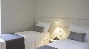 a hotel room with two beds and a telephone at Hotel Real Executive in Aparecida de Goiânia +46 photos