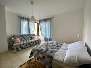 a bedroom with a bed and a couch at Bursztynowa 16 Hel in Hel