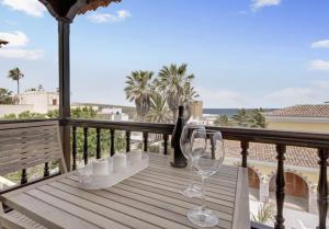 una mesa con 2 copas de vino en el balcón en Graciosa Sunset Apartment, en Los Silos