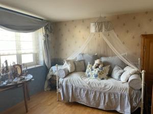 a teddy bear sitting on a bed in a bedroom at Großzügige 3-Zimmer Wohnung in Rümmingen