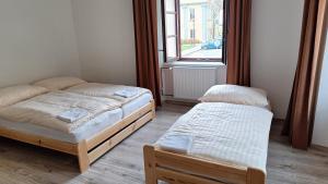 two twin beds in a room with a window at Apartmány Javorník in Javorník