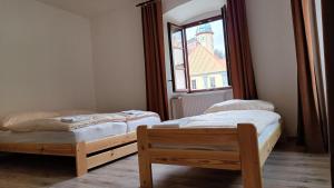 dwa łóżka w pokoju z oknem w obiekcie Apartmány Javorník w Javorníku