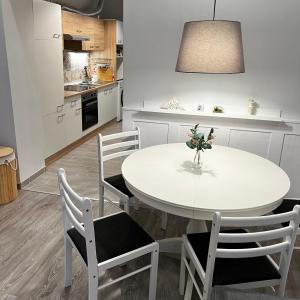 Pázmány Rest Apartman في بودابست: طاولة بيضاء وكراسي في مطبخ