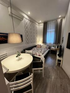 Pázmány Rest Apartman في بودابست: غرفة معيشة مع سرير وطاولة وكراسي
