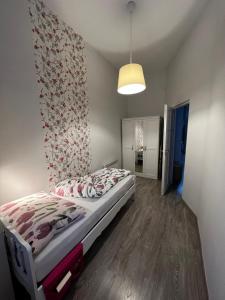 a bedroom with a bed and a wall with flowers at Pázmány Rest Apartman in Budapest