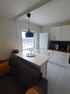 - une cuisine avec une table et un canapé dans une chambre dans l'établissement Small and cute apartment in city center, à Tromsø 7 autres photos