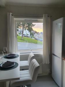 a kitchen with a window and a table and a refrigerator at Small and cute apartment in city center in Tromsø