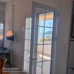 una puerta corredera de cristal con vistas a la playa en Luxury Katakolo in front of the sea near Olympia, en Katakolon