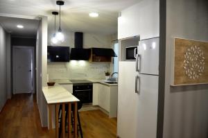 アルスーアにあるREGO DA RAÑA APARTMENTSのキッチン(白い冷蔵庫、テーブル付)