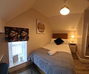 1 dormitorio con cama y ventana en The Manor Guest Accommodation, en Dungiven
