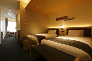 a hotel room with two beds and a window at Kanazawa Sainoniwa Hotel in Kanazawa