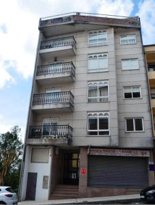 un edificio con balcones en un lateral en REGO DA RAÑA APARTMENTS, en Arzúa