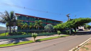 a building on a street with palm trees and a road at Sevilha Park Hotel in Colorado