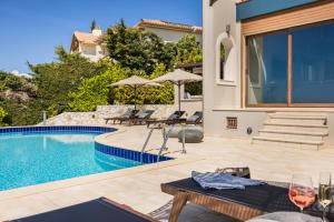 a villa with a swimming pool and a patio at Luxury Villa Karmaniolos Fiskardo Kefalonia in Fiskardo