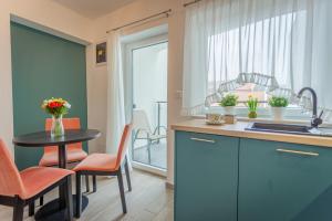 una cucina con tavolo, lavandino e finestra di Viktória Apartman a Gyula
