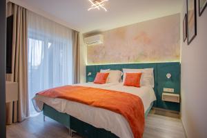 una camera da letto con un grande letto con una coperta arancione di Viktória Apartman a Gyula