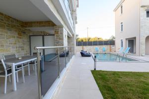 a patio with a table and chairs and a swimming pool at Momento Luxury Apartments walking distance from the beach in Nikiana
