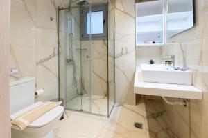 a bathroom with a shower and a toilet and a sink at Momento Luxury Apartments walking distance from the beach in Nikiana