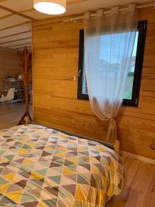 Schlafzimmer mit einem Bett und einem Fenster in der Unterkunft L'écolodge de Laeti in Lunéville