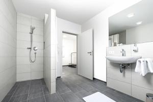 a white bathroom with a sink and a shower at Living797 in Albstadt