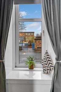 een raam met een potplant op een vensterbank bij Cheerful Stays - Jamson Pl 3 Bed Apartment in Edinburgh