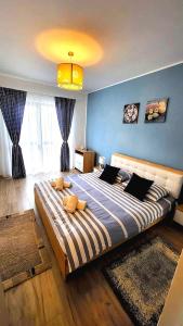 a large bed in a bedroom with a blue wall at STEFI ' s Apartament in Sibiu