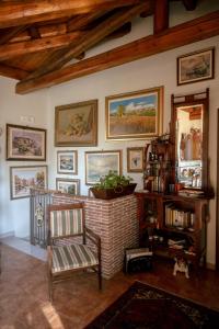una sala de estar con una silla y pinturas en la pared en Tetti & Chiese - Authentic Sicilian Rooftop, en Catania