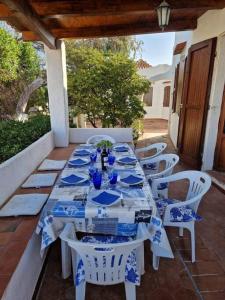 einen Tisch mit blauen und weißen Tellern und Stühlen in der Unterkunft Casa Cicci in pole position di fronte al mare in Marina di Sorso