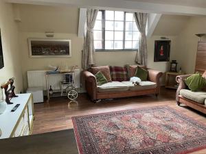 a living room with a couch and a dog laying on a rug at Cosy and Stylish 1BD-Limehouse in London