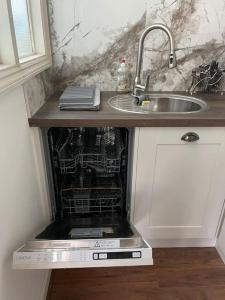 un lavavajillas en una cocina junto a un fregadero en Cosy and Stylish 1BD-Limehouse en Londres