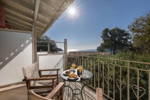 einen Tisch mit Speisen und Getränken auf dem Balkon in der Unterkunft Villa Anthoussa in Palaiokastritsa in Korfu-Stadt