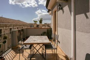 una mesa y sillas en el balcón de una casa en Tetti & Chiese - Authentic Sicilian Rooftop, en Catania