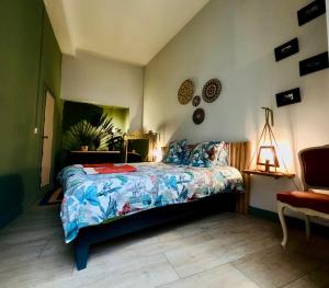 a bedroom with a bed with a blue comforter at Chambres d hôtes Koko et Baobab in Bordeaux