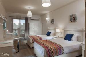 ein Hotelzimmer mit 2 Betten und einem Balkon in der Unterkunft شقه فندقيه in Alexandria