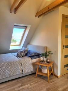 a bedroom with a bed and a table at Sodyba Preiloje in Neringa